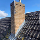 Brick chimney with new lead flashing on a tiled roof