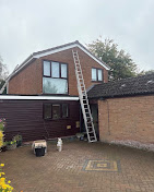 Family home with a roofing ladder up to the tiled roof